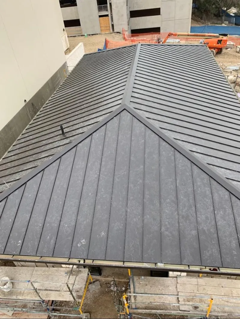 Commercial metal roof construction with crane equipment in Middlebury